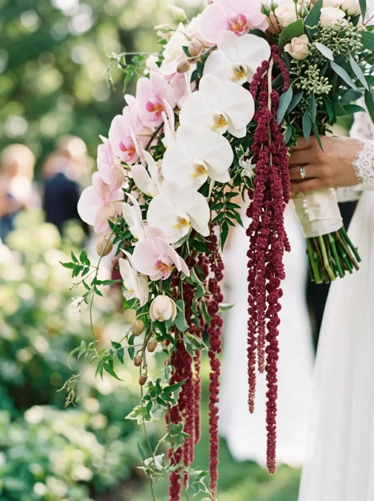 Close-up of cascading bouquet with orchids and greenery flowing downward in a romantic design