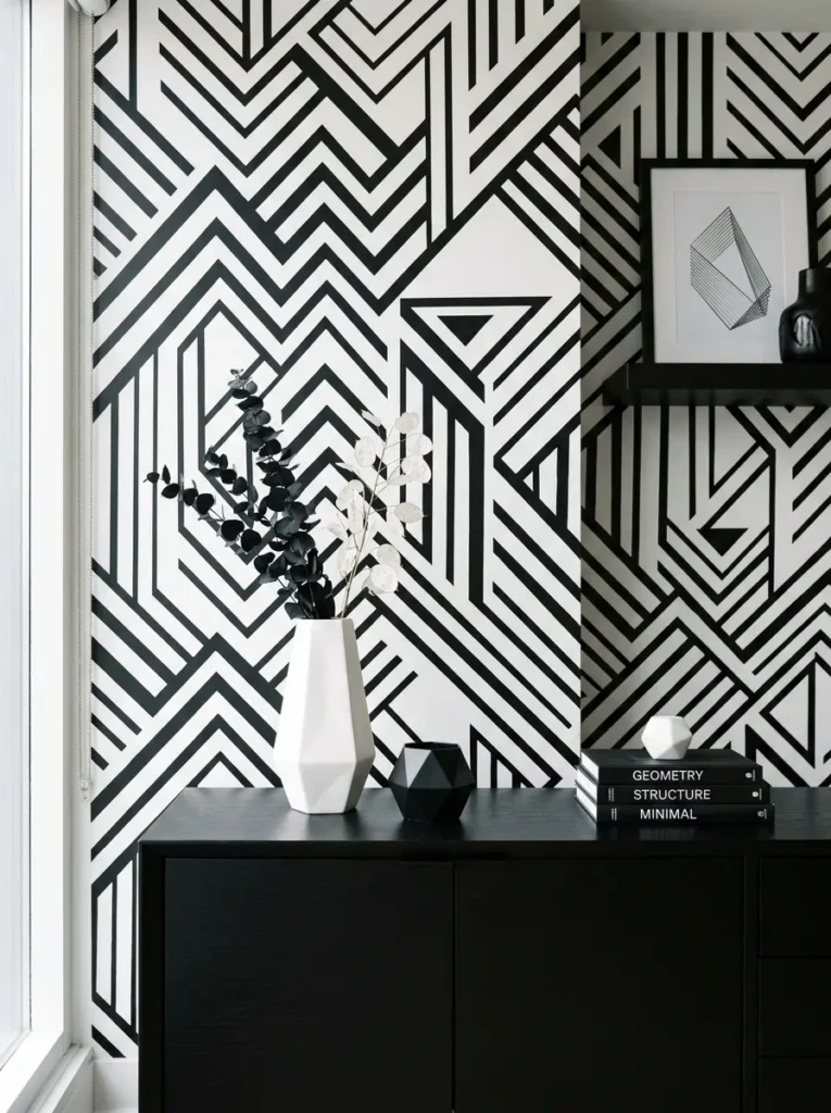 Close-up of black and white geometric wallpaper in a clean, modern bedroom interior