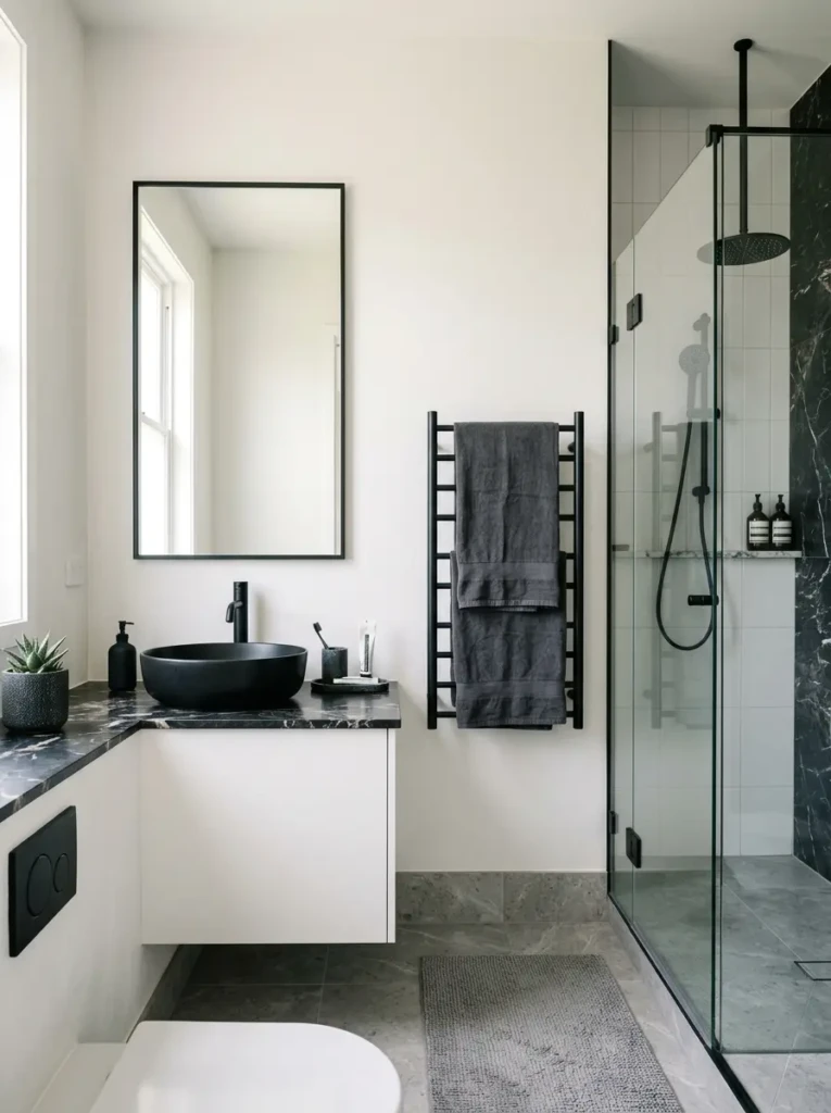 Elegant bathroom with black hardware, marble accents, and a sleek towel rack.